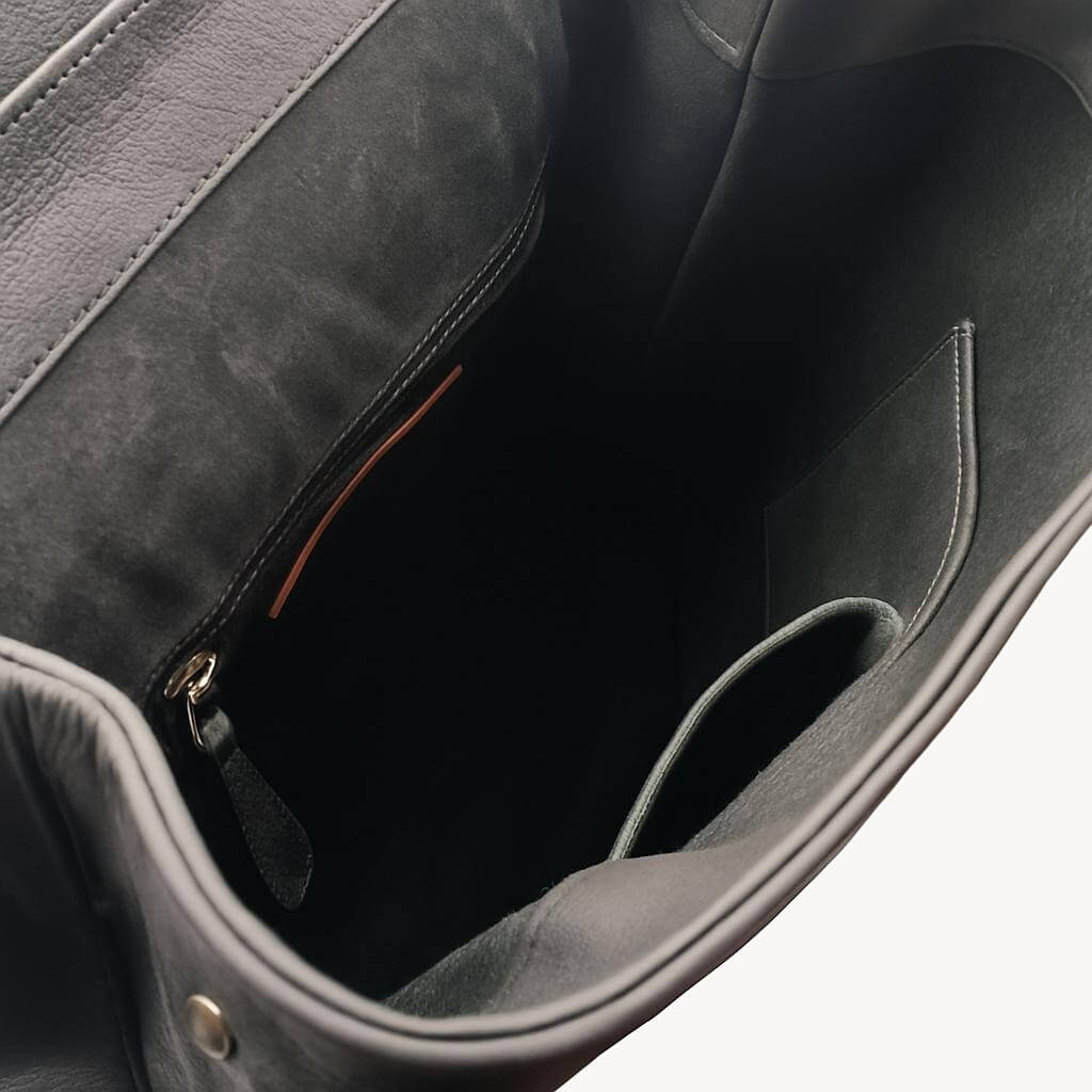 Open interior of Solstice with zip pocket and two slip pockets inside black leather backpack