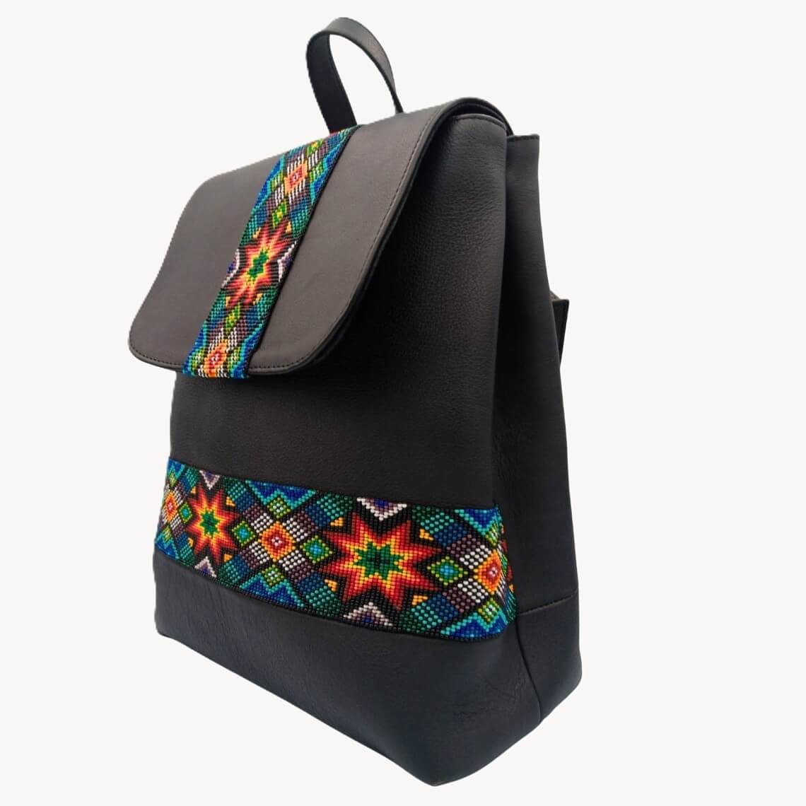 Angled view of Solstice showing beaded flap strap, curved flap, and front beaded band on black leather backpack