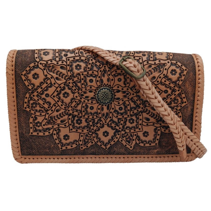 Front view with braided adjustable strap draped across the mandala tooled leather bag.