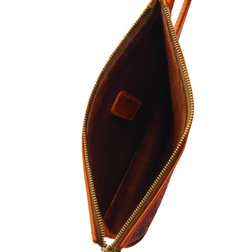 spacious interior with natural suede finish inside full‑grain leather clutch