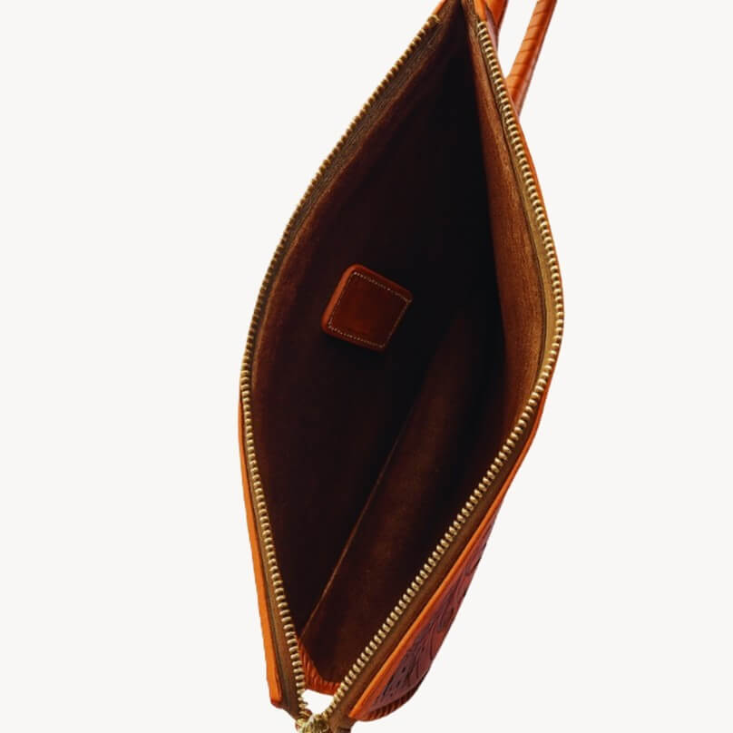 spacious interior with natural suede finish inside full‑grain leather clutch