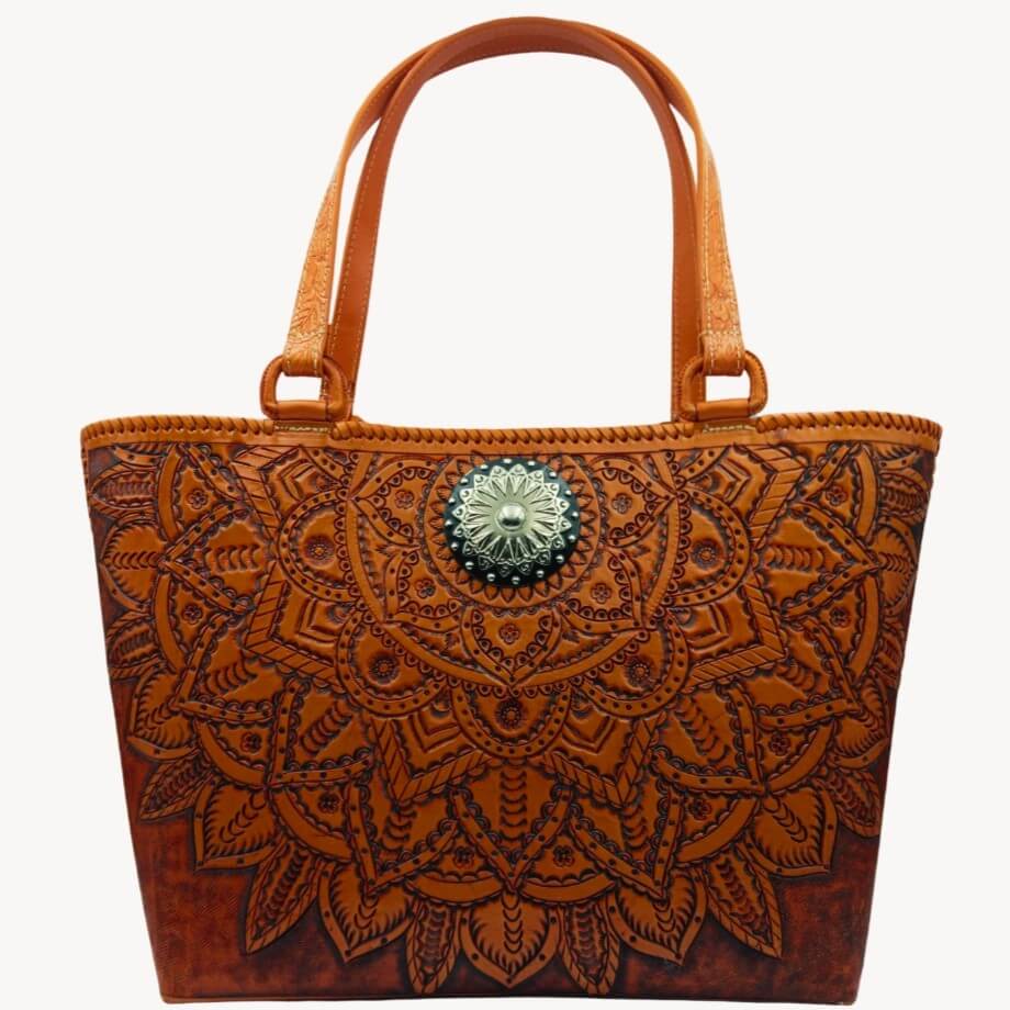 Upright front view of handmade full‑grain leather tote with mandala tooling.