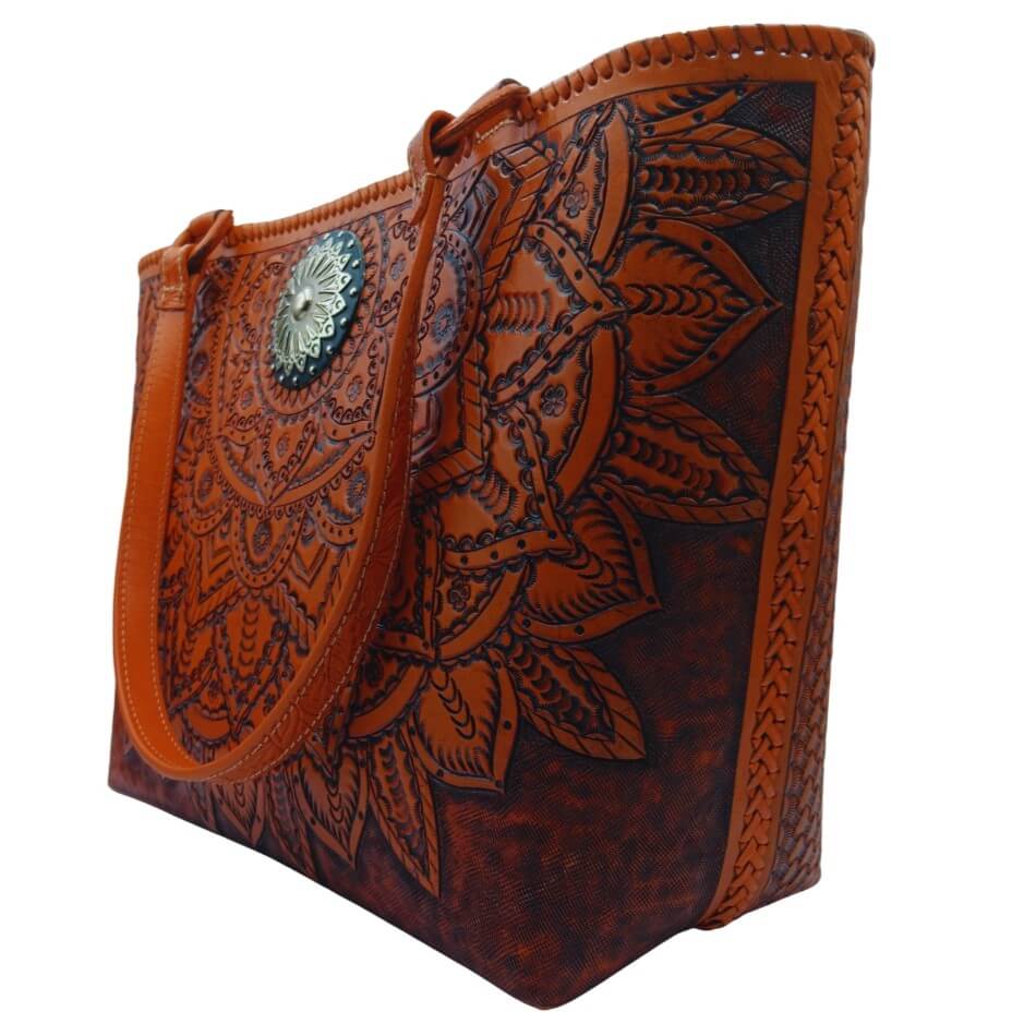 Three‑quarter view of tooled leather purse with marigold mandala and antique‑silver concho.