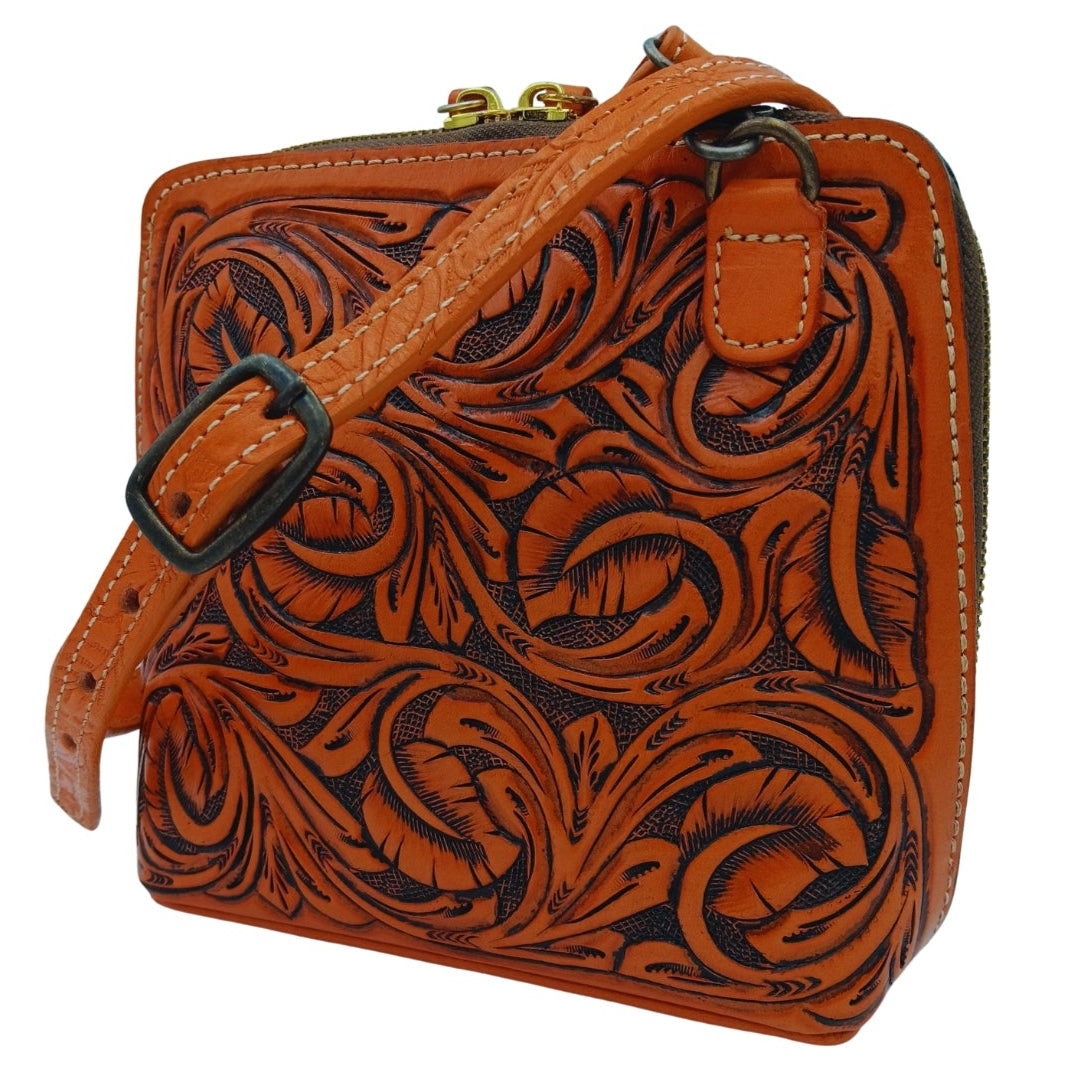 Adjustable removable crossbody strap attached to hand‑tooled leather bag