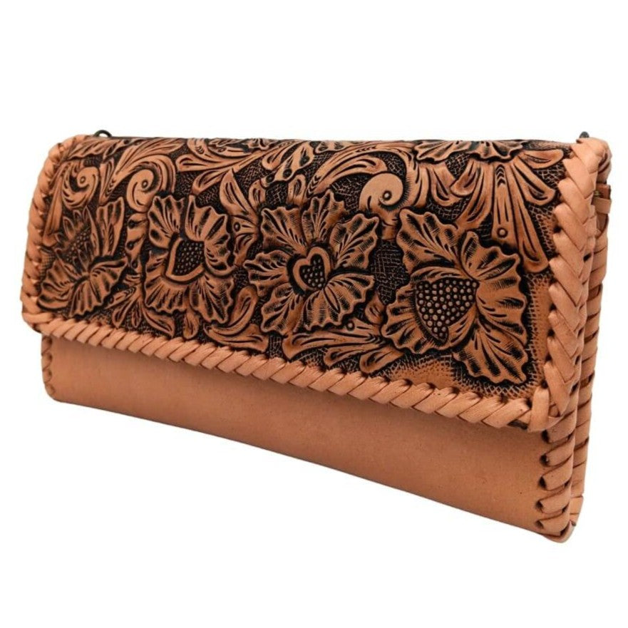 Angled left view showing floral/leaf tooling and braided edge on full grain leather clutch.