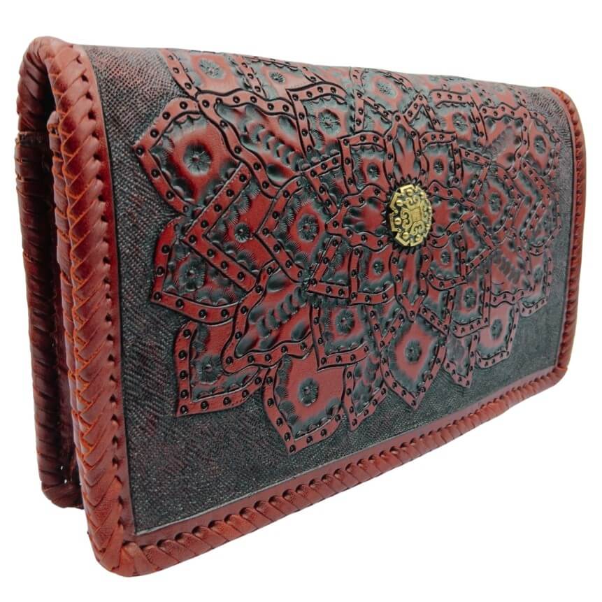 Left‑angle view showing raised mandala tooling and whipstitch edges on crimson leather crossbody.
