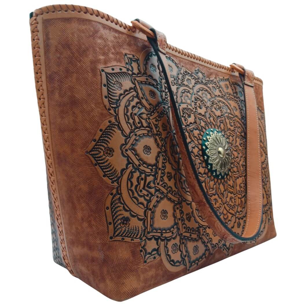 Angled left—tooled leather purse showing mandala detail and strap drop.