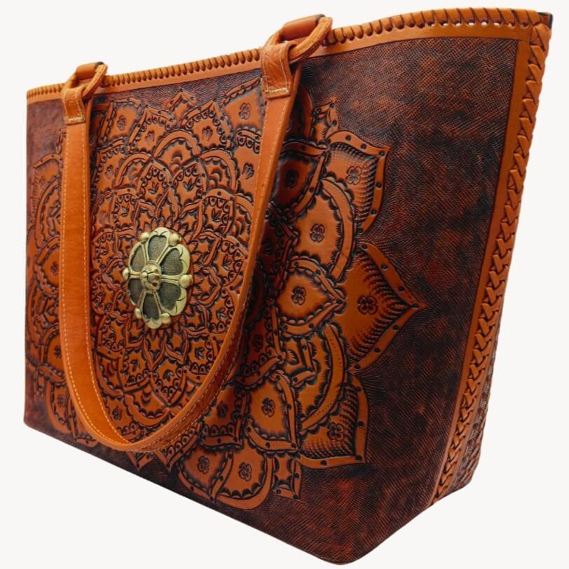 Hand‑tooled mandala leather purse, angled left, laced sides visible.