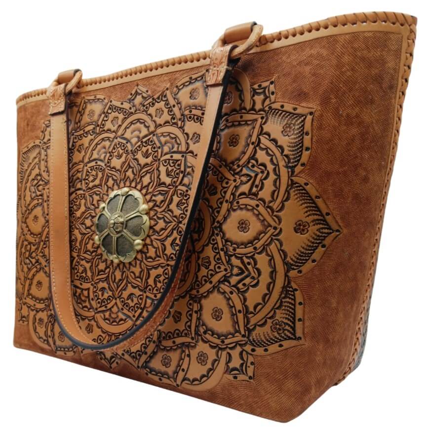 Hand‑tooled mandala leather purse, angled left, laced sides visible.