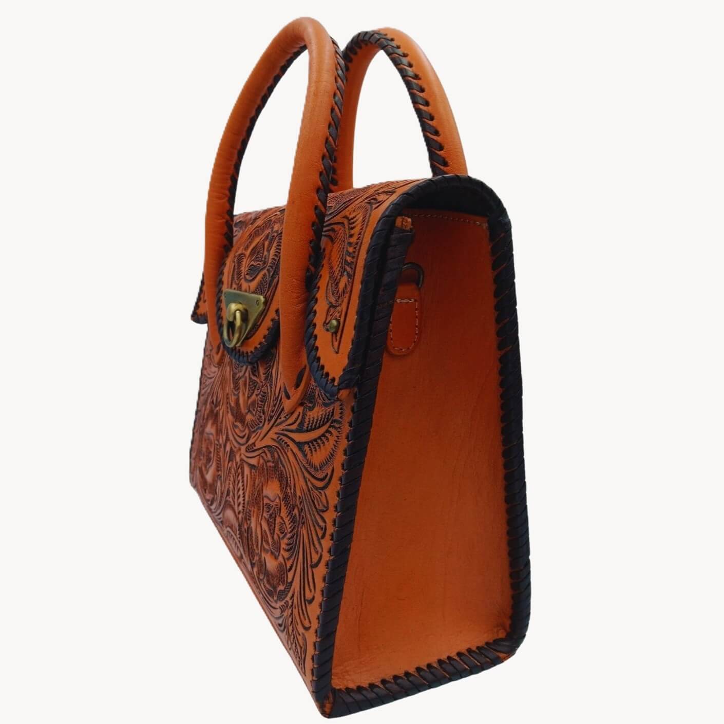 Side profile showing whipstitched edges and top handles of the hand‑tooled Full Grain Leather mini tote