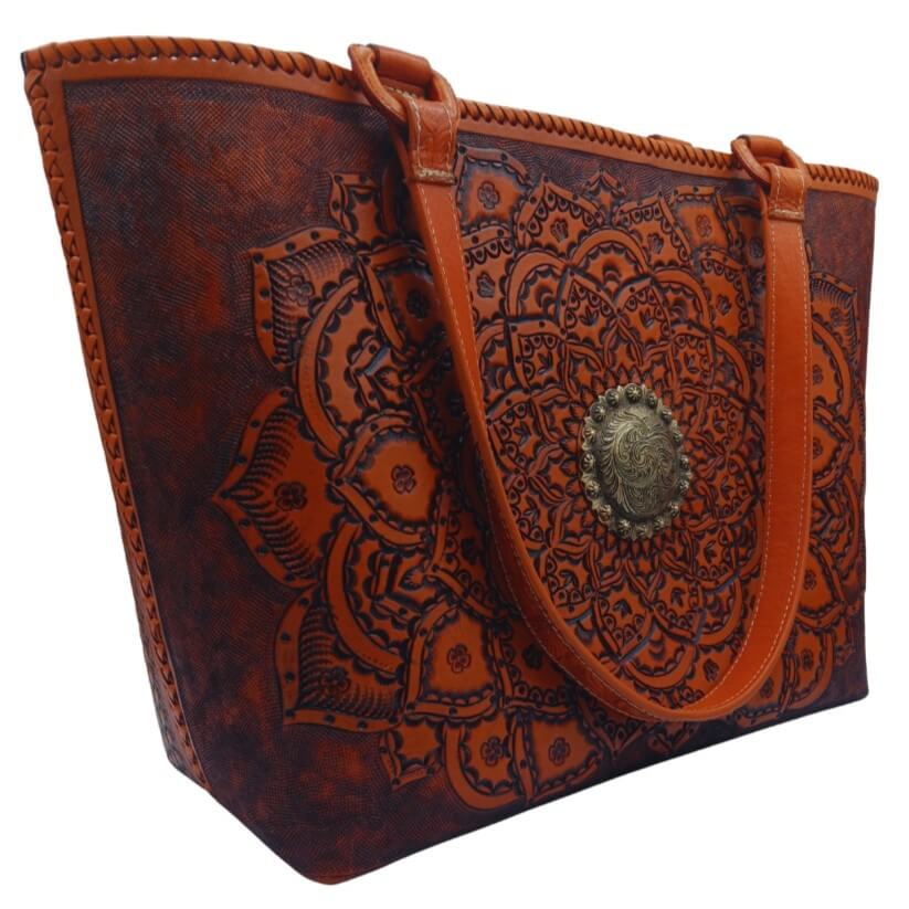 Angle showing mandala tooling, hand‑laced rim, and shoulder handles.