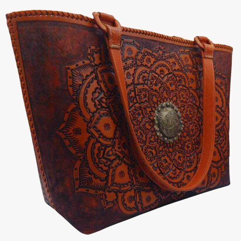 Angle showing mandala tooling, hand‑laced rim, and shoulder handles.