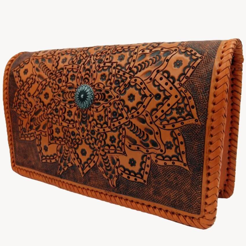 Three-quarter view of Sedona Mandala Tooled Leather Crossbody with sunflower medallion center design burnt orange