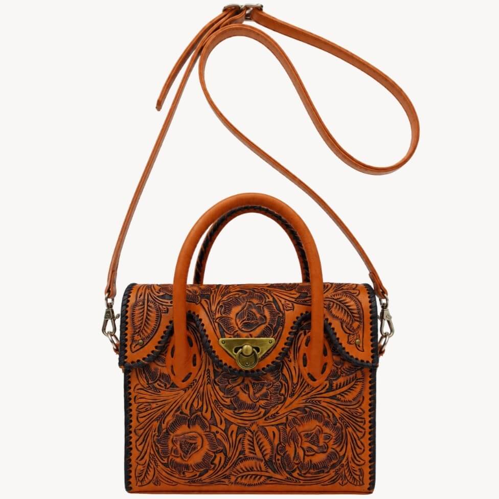 Front profile showing whipstitched edges and top handles of the hand‑tooled Full Grain Leather mini tote and the strap of the handbag