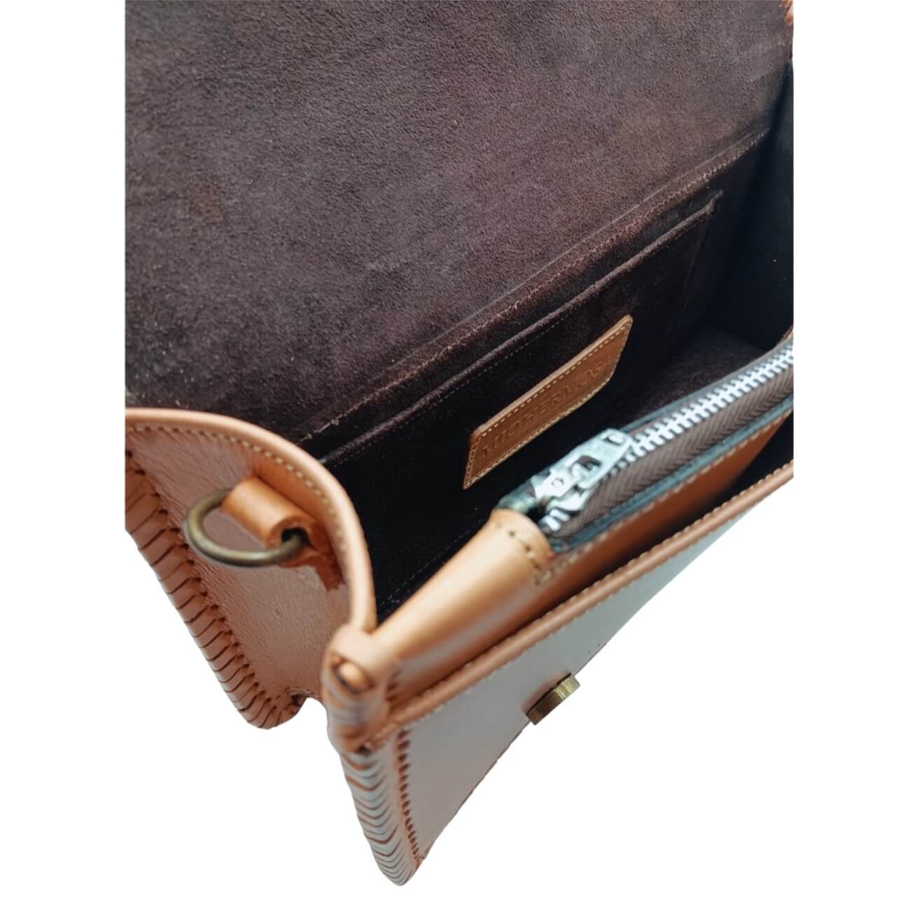 Interior view of suede‑lined crossbody with zipper pocket and slip pocket.