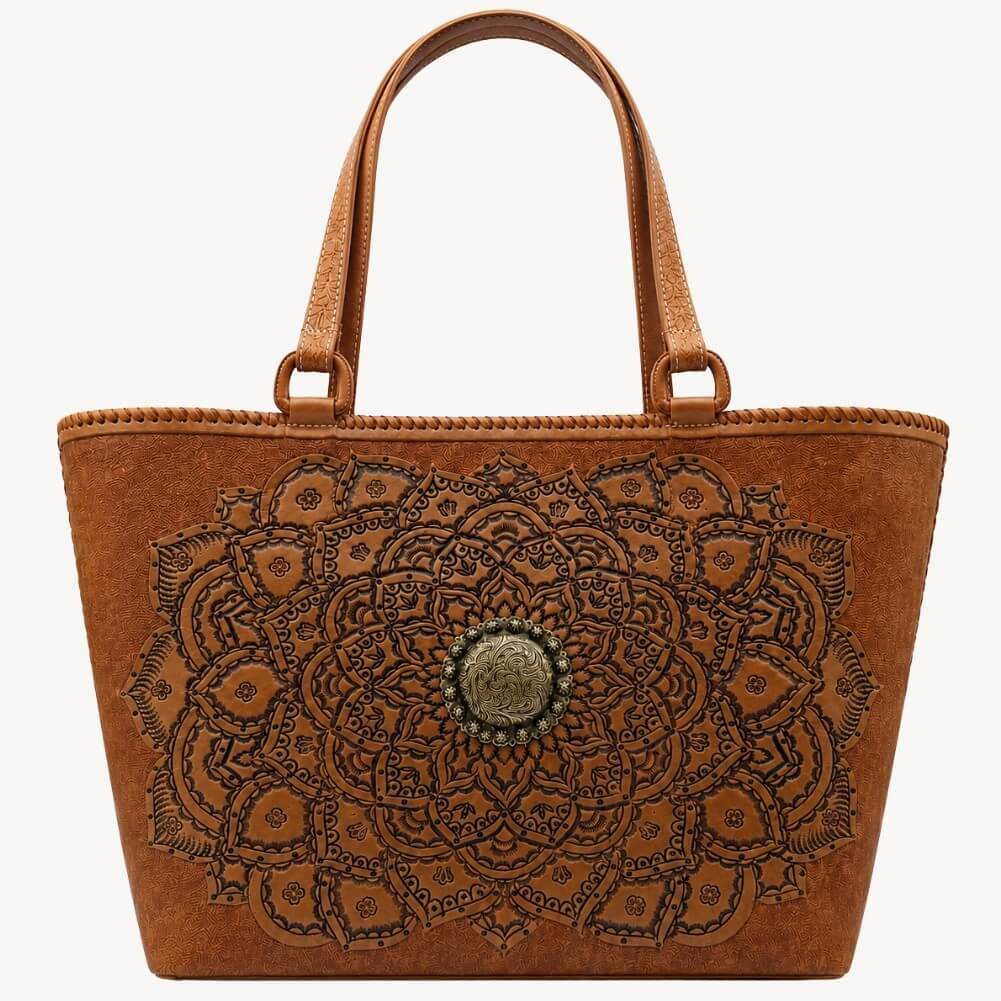 Cognac/burnished brown nude color tooled leather tote with floral mandala design, double shoulder straps, and round antique medallion hardware on a white background.