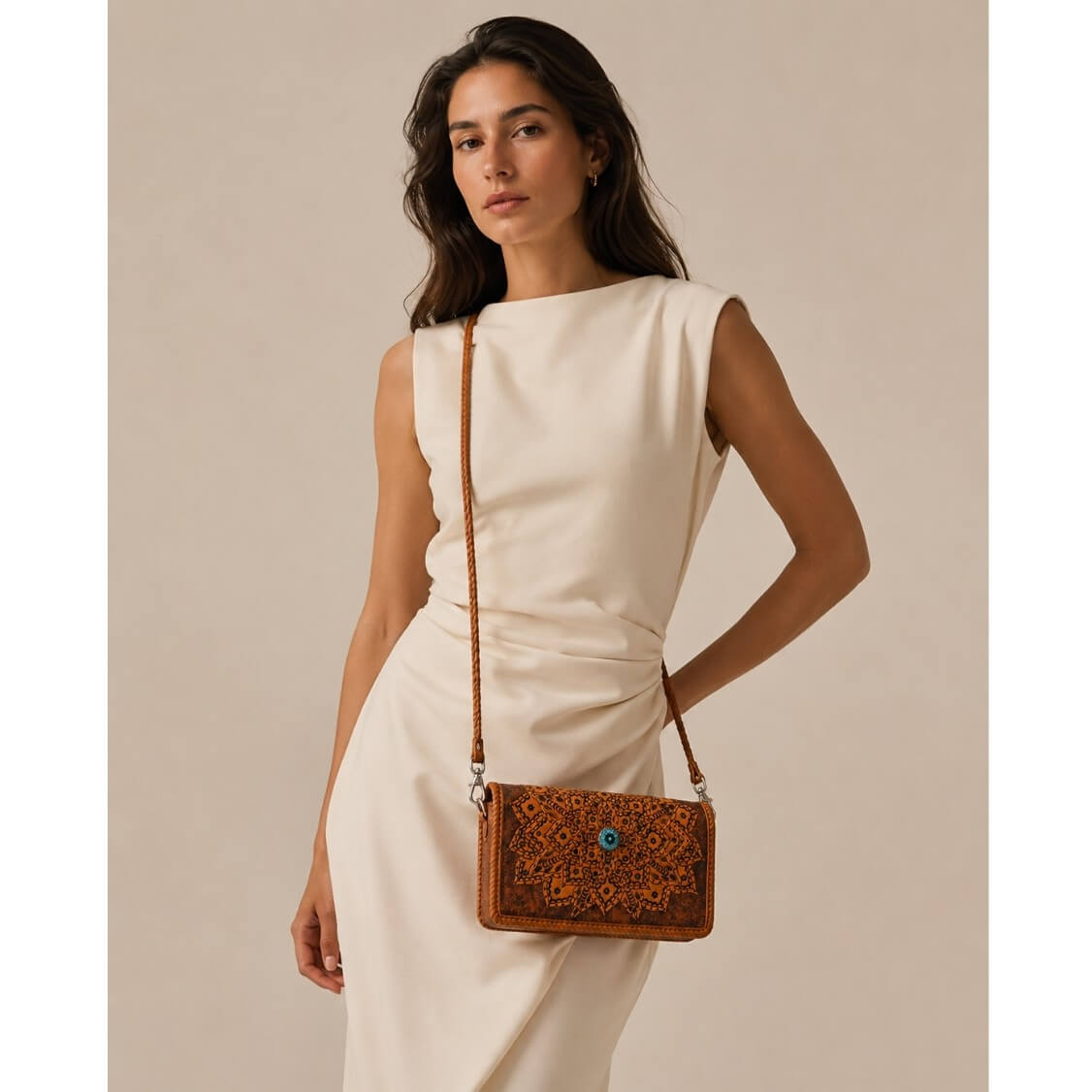 Elegant full-grain leather crossbody bag with floral mandala design styled with a modern cream dress