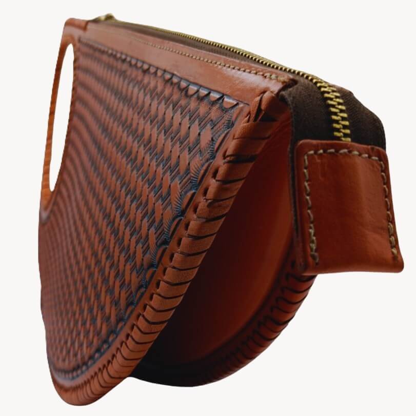 hand‑laced leather edges and zipper detail on crescent clutch