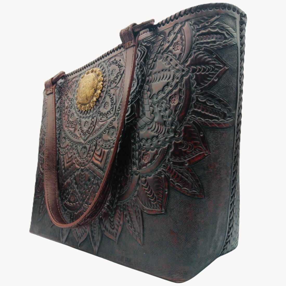 Tooled leather tote with concho medallion and leaf details, angled view.