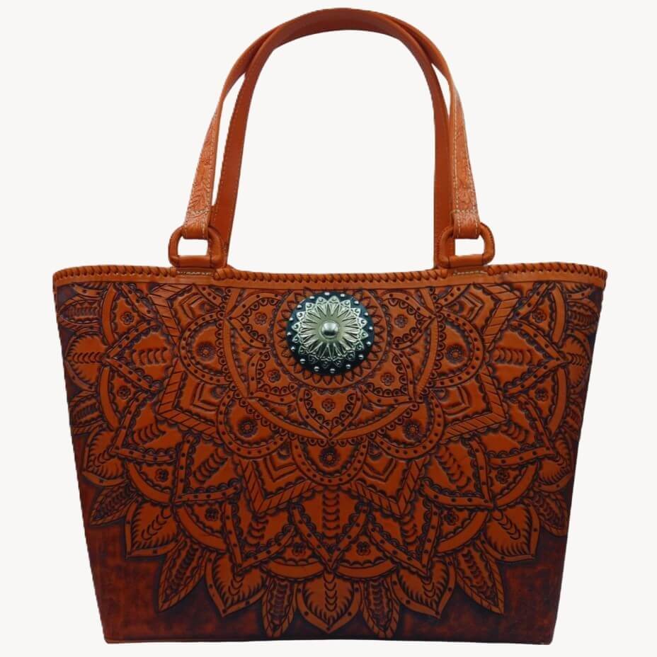 Upright front view of handmade full‑grain leather tote with mandala tooling.