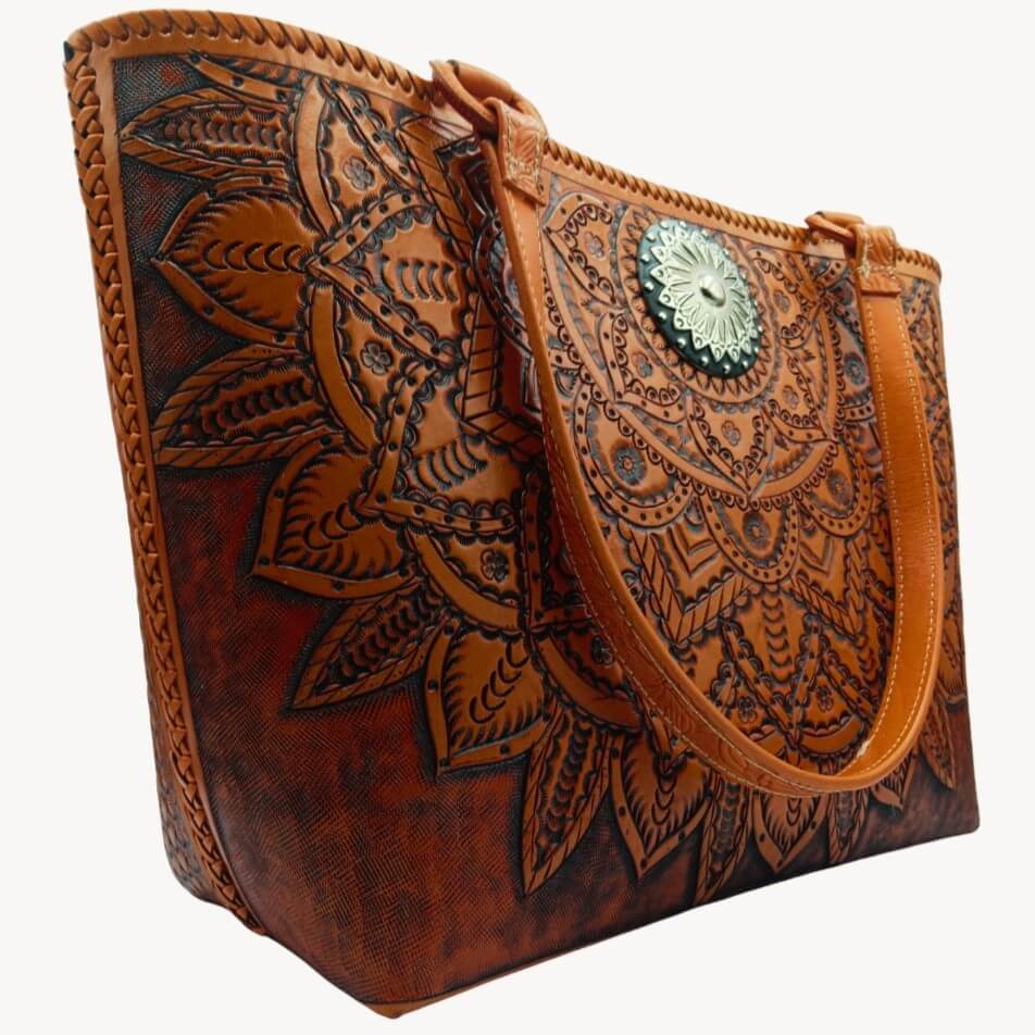 Side angle showing hand‑laced edge and deeply tooled front panel on full‑grain leather tote