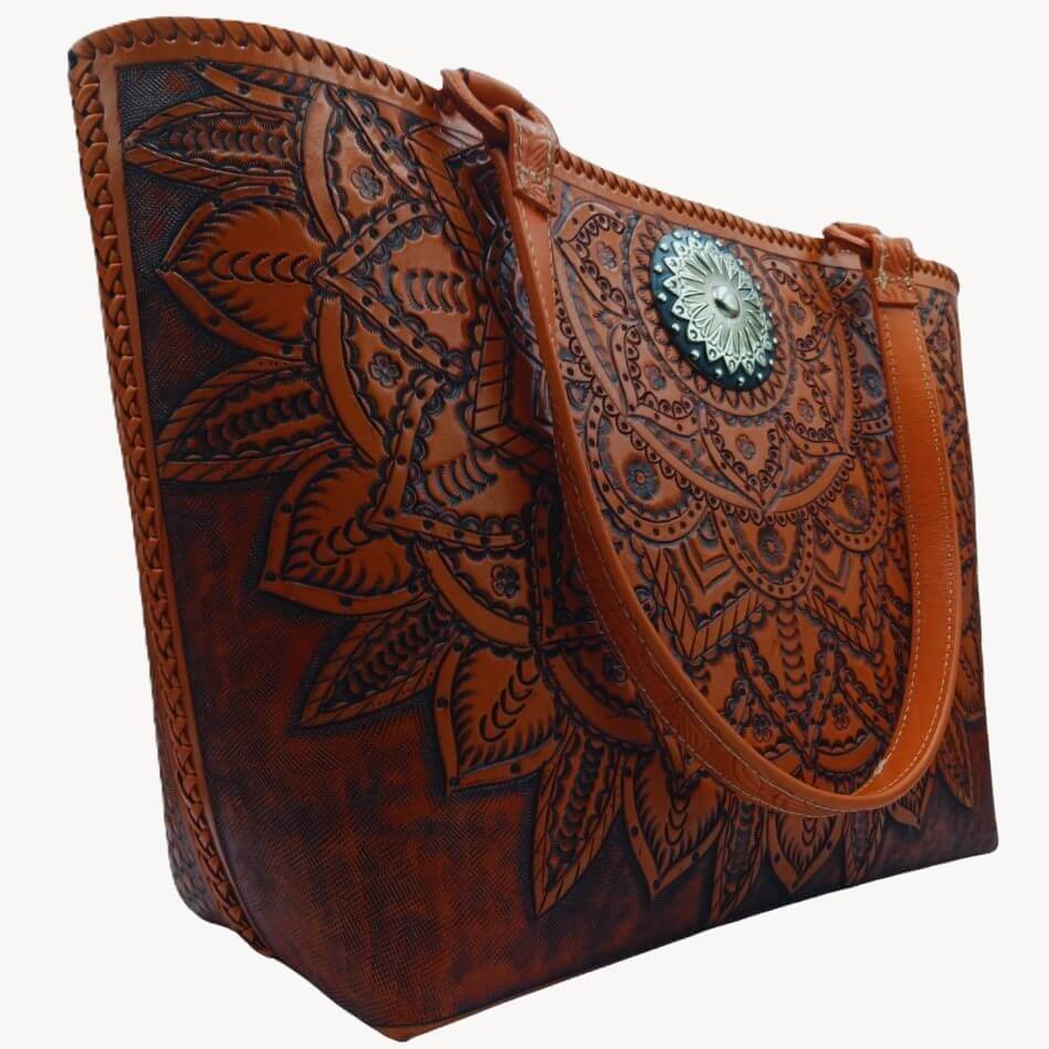 Side angle showing hand‑laced edge and deeply tooled front panel on full‑grain leather tote
