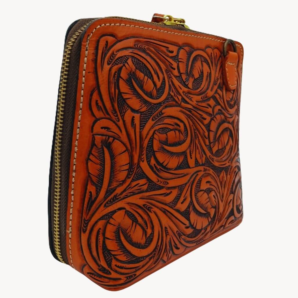 Side profile showing depth and secure top zip closure on leather crossbody