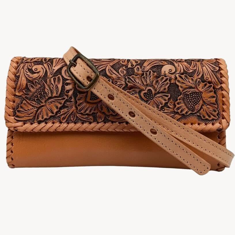 Clutch with adjustable removable crossbody strap laid across the front.