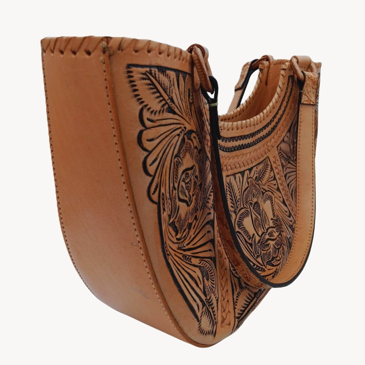 “Left angle close‑up of floral hand tooling and braided edge on Flor de Cordoba satchel