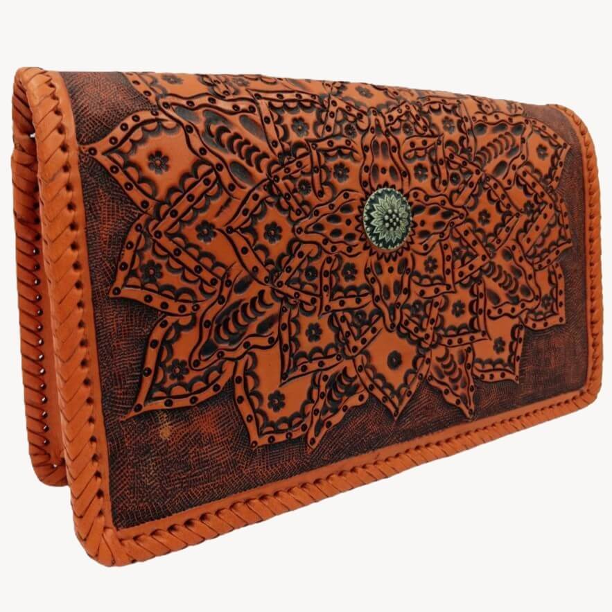 Tooled leather purse with layered mandala petals and hand‑laced edges—angled view