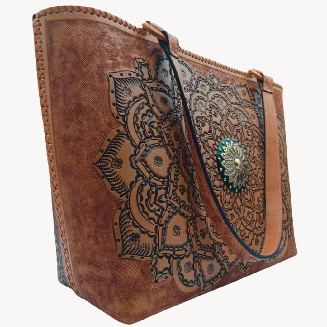 Angled left—tooled leather purse showing mandala detail and strap drop.