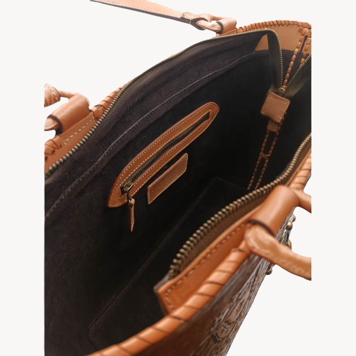 Interior—suede lining with zip pocket and two slip pockets; zip‑top closure.