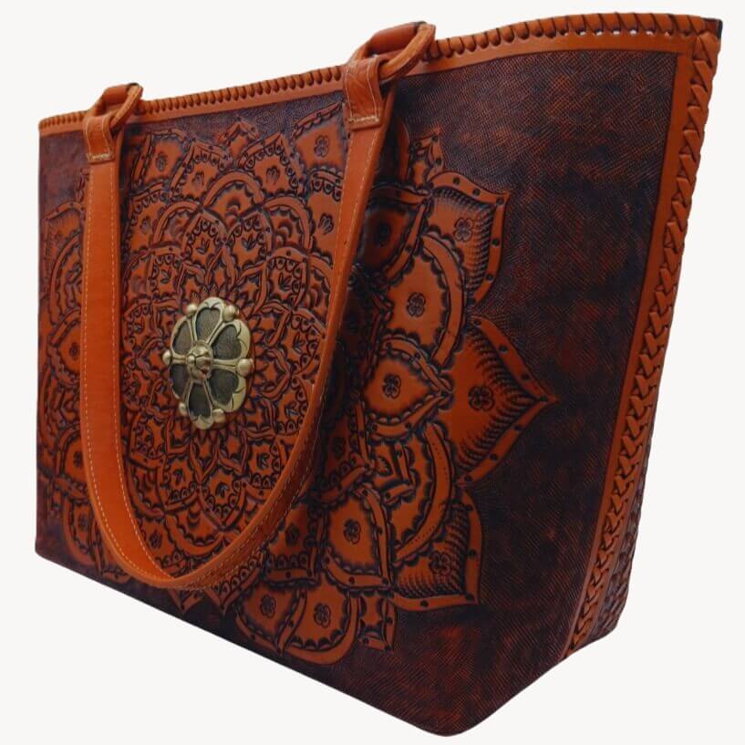 Hand‑tooled mandala leather purse, angled left, laced sides visible.