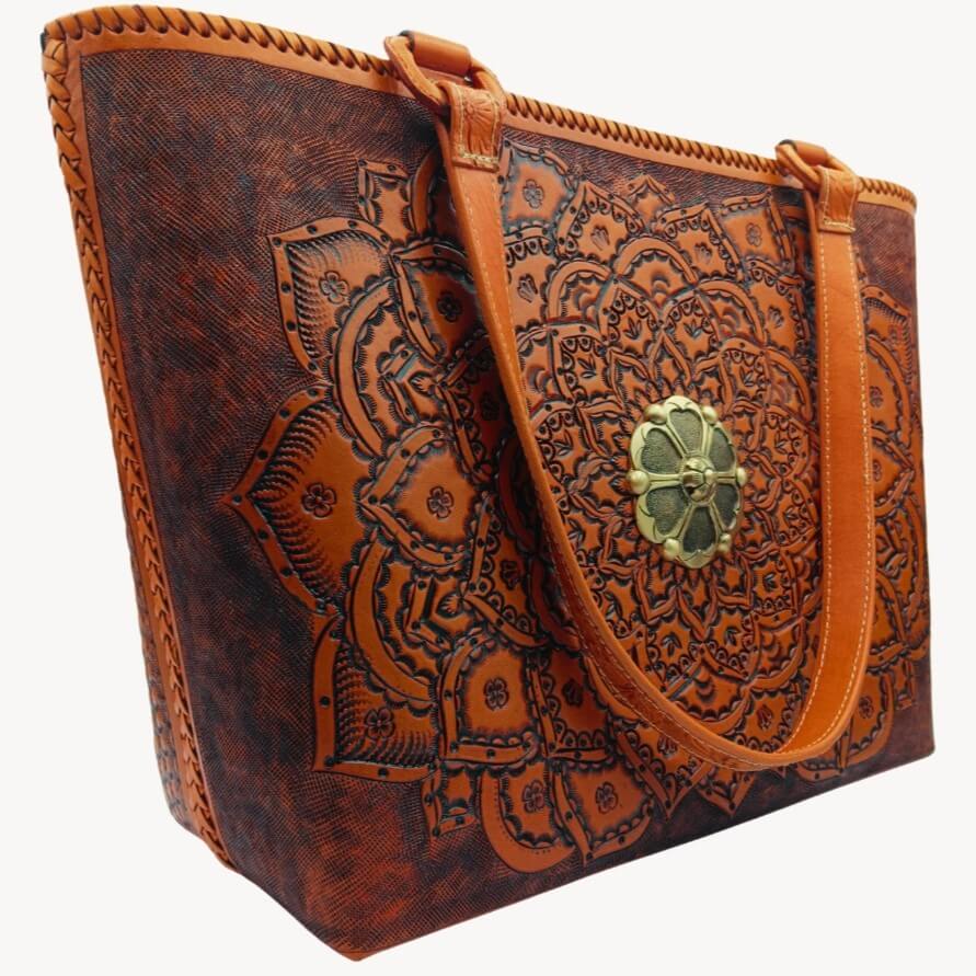 Full‑grain leather mandala tote, angled right, floral handles detail.