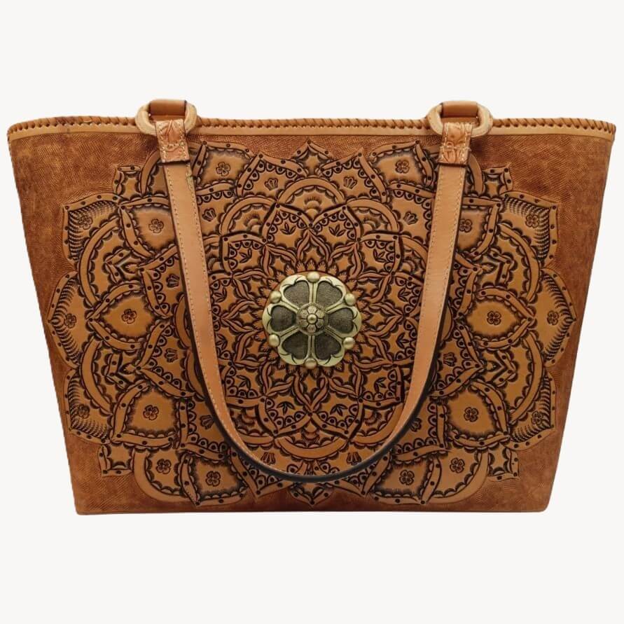 Full‑grain leather tote with embossed mandala and brass medallion, front view.