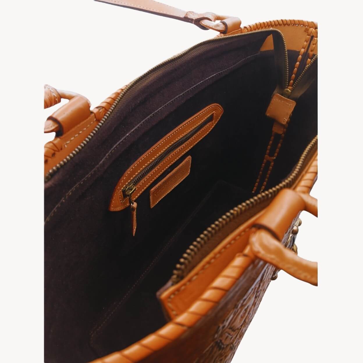 Suede‑lined interior with zip pocket and two slip pockets, zip closure.