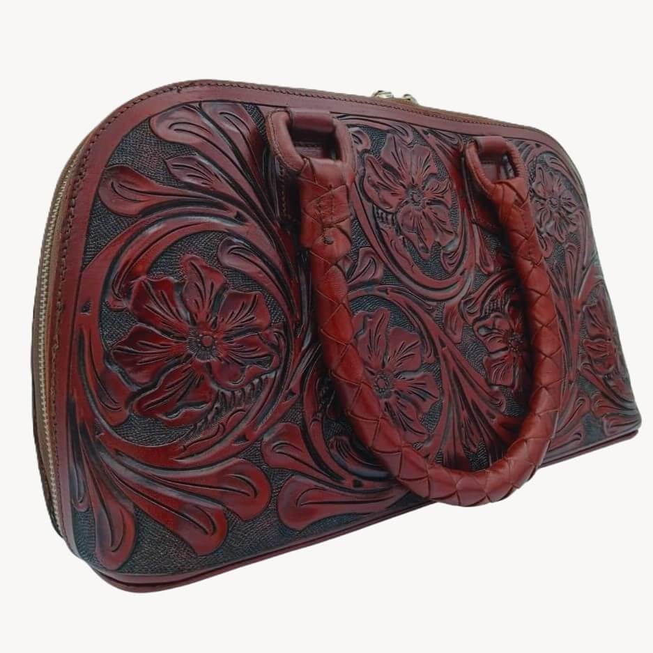 Tooled leather purse in deep burgundy left three quarter view