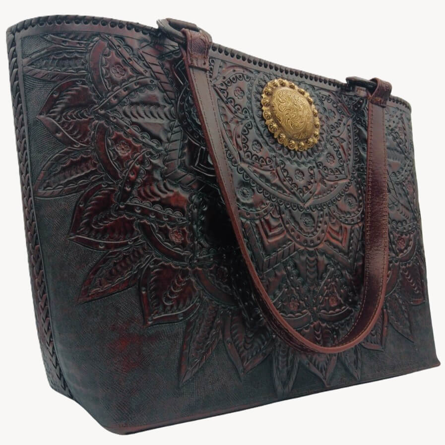 Hand‑tooled mandala leather purse, side angle showing whipstitched edge.